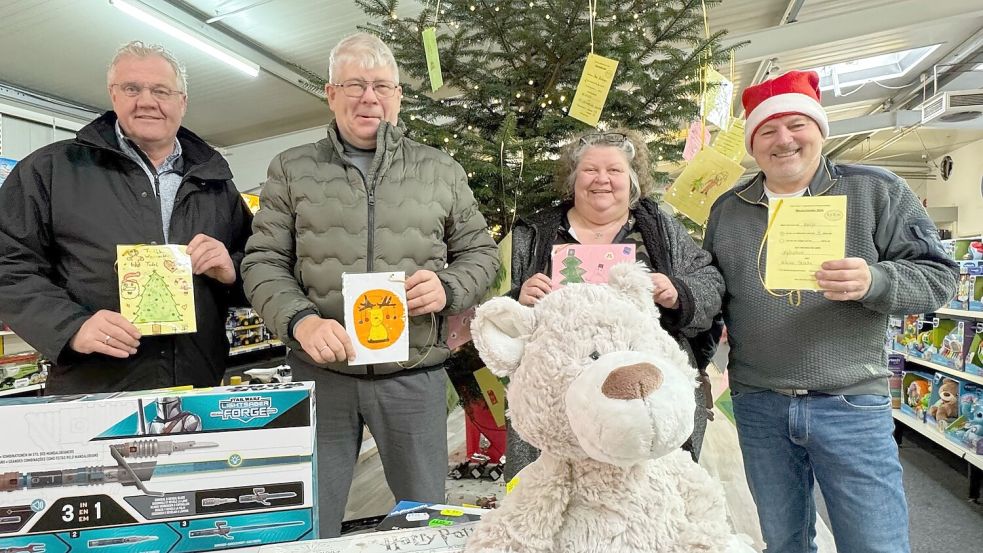 Heiko Kruse und Gerhard Barz vom Gewerbeverein sowie Ruth Oost und Christoph Meyer von der Tafel waren beim Aufstellen des Wunschbaums in Moordorf dabei. Foto: Holger Janssen