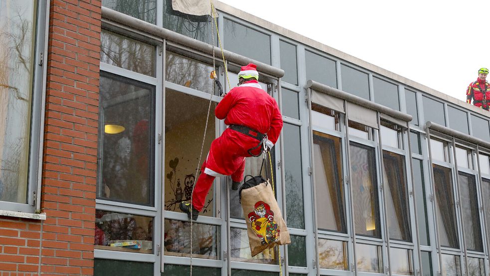 Mit Unterstützung seiner Feuerwehrkollegen seilte sich der Nikolaus elegant vom Dach der Klinik ab. Foto: Romuald Banik