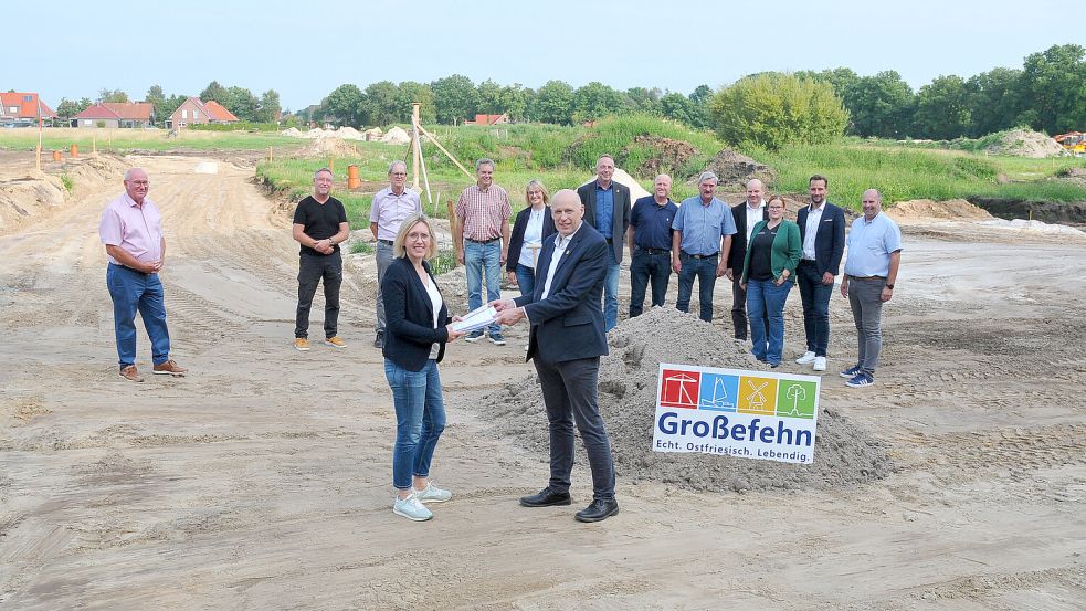 Erst vor wenigen Wochen startete die Vermarktung: Großefehns Bürgermeister Erwin Adams übergab die Bauunterlagen für „Claaßens Land“ an Dörte Kaminski, Geschäftsführerin der RVB-Immobilien. Dahinter stehen (von links) Frerich Lienemann von der Firma Liebau GmbH, Thorsten Kunst, Gert Gellmers (beide Thalen Consult), Ralf Biller (Bauamt Gemeinde Großefehn), Agnes Frühling (RVB Immobilien), Bauamtsleiter Detlef Meyer, Günter Siefken (Fachgruppenleiter Bautechnik), Ortsbürgermeister Friede Schoone, Ingo Cirksena, Daika Reck, Timo Buß (alle RVB) sowie Bauausschussvorsitzender Wolfgang Dirksen. Foto: Gemeinde Großefehn