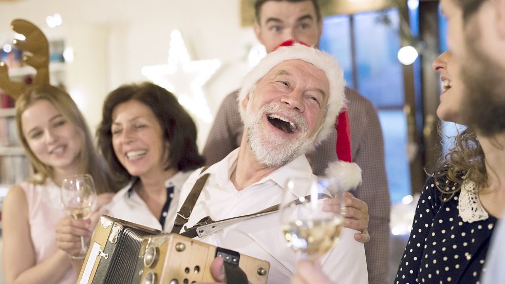 Nur Bildagenturen und Politiker glauben, dass Weihnachten mit der Familie so aussieht. Alle anderen wissen es besser: Wenn Opa das Akkordeon rausholt, ist der Weihnachtshorror perfekt. Foto: imago images/Westend61