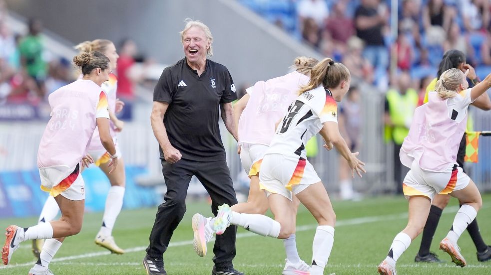 Jubel über Olympia-Bronze: Horst Hrubesch und die Nationalspielerinnen. Foto: Marcus Brandt/dpa