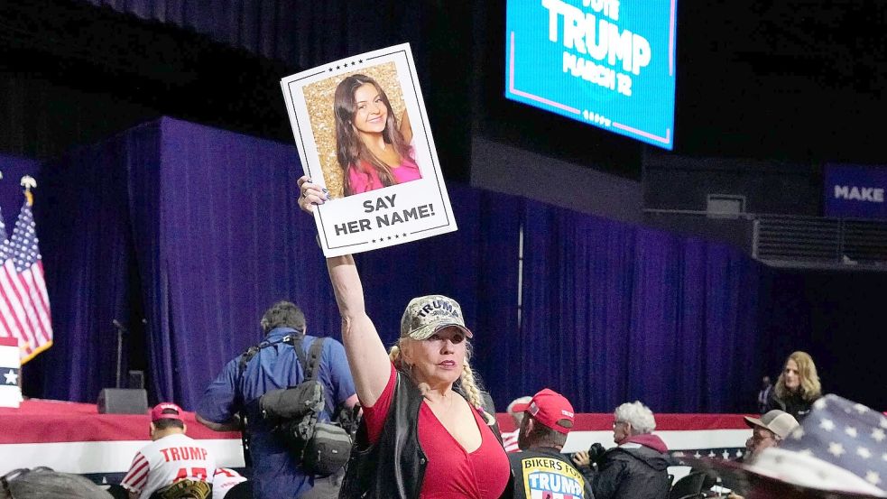 Eine Trump-Unterstützerin hält bei einer Wahlkampfveranstaltung im Bundesstaate Georgia ein Schild in die Höhe, dass die ermordete Studentin Laken Riley zeigt. (Archivbild) Foto: Mike Stewart/AP