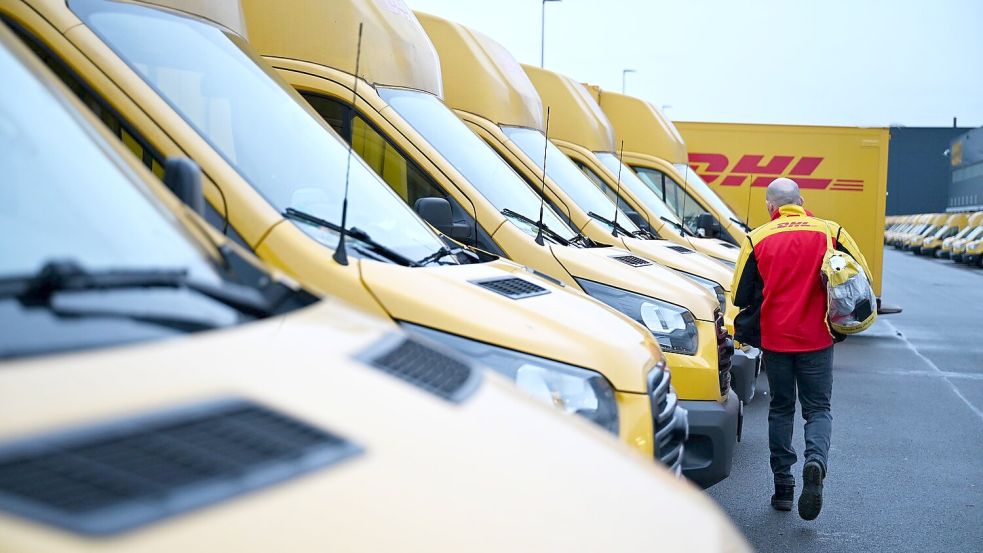 Auch er fährt Stromer: ein DHL-Paketbote auf dem Weg zu seinem Elektro-Transporter. Foto: Wolf von Dewitz/dpa