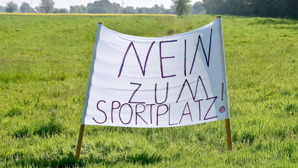 Dort, wo in Marienhafe die neue Sportstätte gebaut werden soll, stand im Mai vergangenen Jahres dieses Protestbanner. Foto: Thomas Dirks