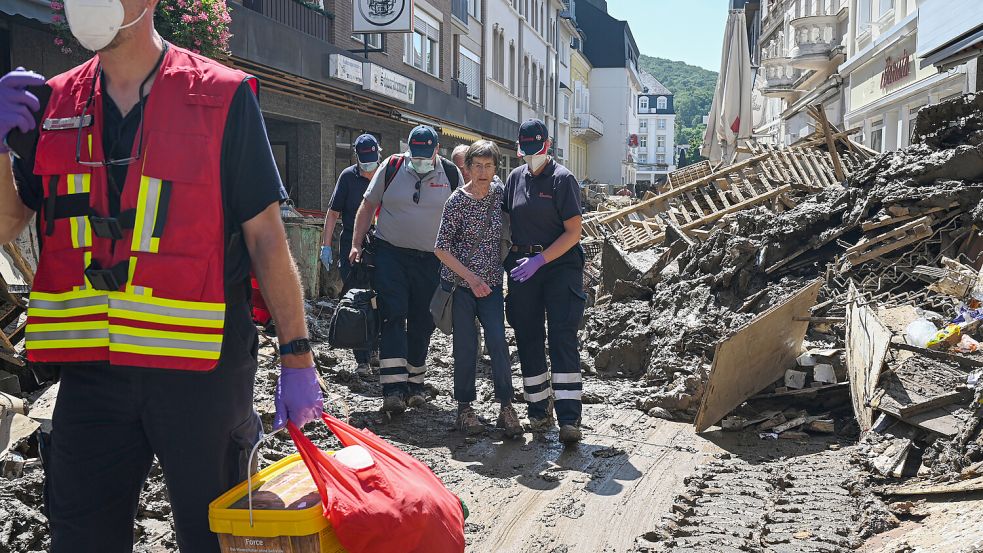 Bei der Hochwasser-Katastrophe 2021 starben allein an der Ahr 135 Menschen: In Bad Neuenahr-Ahrweiler begleiten Hilfskräfte eine Seniorin aus ihrer Wohnung. Foto: dpa/Johanniter Unfall Hilfe e.V./Lena Mucha