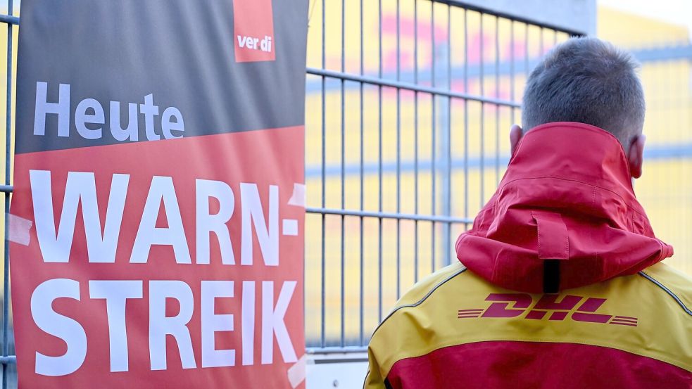 Streikposten am Werkstor: Ein DHL-Mitarbeiter hat die Arbeit niedergelegt und schaut auf eine Zustellbasis, in der er sonst arbeitet. Foto: Wolf von Dewitz/dpa