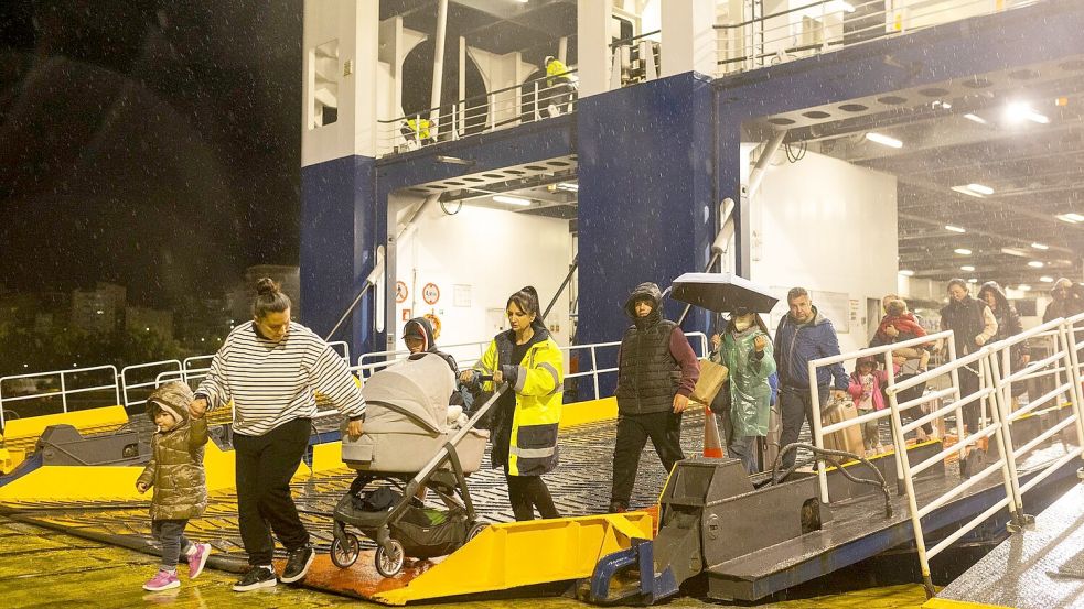 Menschen steigen im Hafen von Piräus von einer Fähre, mit der sie Santorini verlassen haben. Foto: Socrates Baltagiannis/dpa