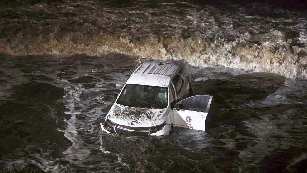 Ein Fahrzeug der Feuerwehr wurde von einer Schlammlawine ins Meer gespült. Foto: Ethan Swope/AP/dpa