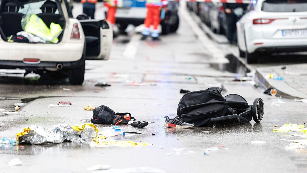 Kleidung und ein Kinderwagen liegen nach dem Anschlag auf der Straße. Foto: Matthias Balk/dpa