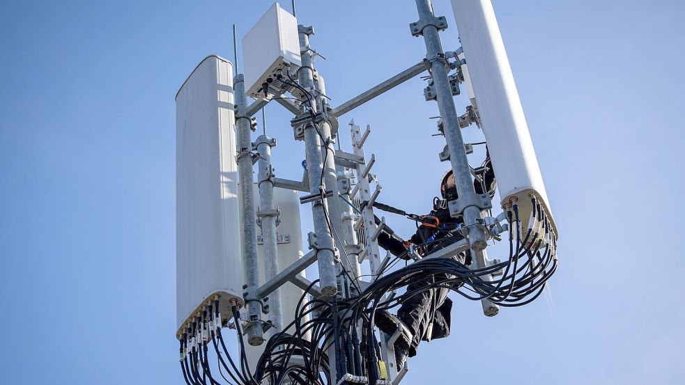 Einer von Zehntausenden Mobilfunk-Masten in Deutschland - hier einer, an dem gerade ein Techniker arbeitet. Foto: Daniel Karmann/dpa