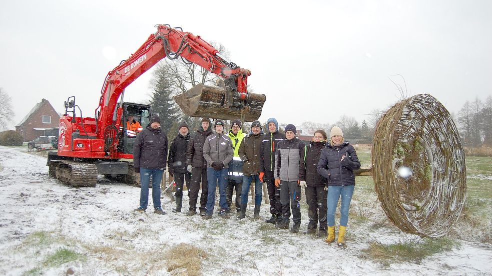 Stellten das Storchennest gemeinsam auf: Alfred Christochowitz (im Bagger; von links), Ralf Adelmund (Grundstückseigentümer), Helmut Hanssen (Nabu Wiesmoor-Großefehn), Schüler Gabriel Vincent Kissinger, Schüler Ben-Niklas Schoone, KGS-Lehrer Erwin Renken, BBS2-Lehrer Wolfgang Bünting, Schüler Marcel Loets, Schüler Ole Tammen, Schülerin Jana Herchler und KGS-Lehrerin Sandy Meinecke. Foto: Imke Cirksena