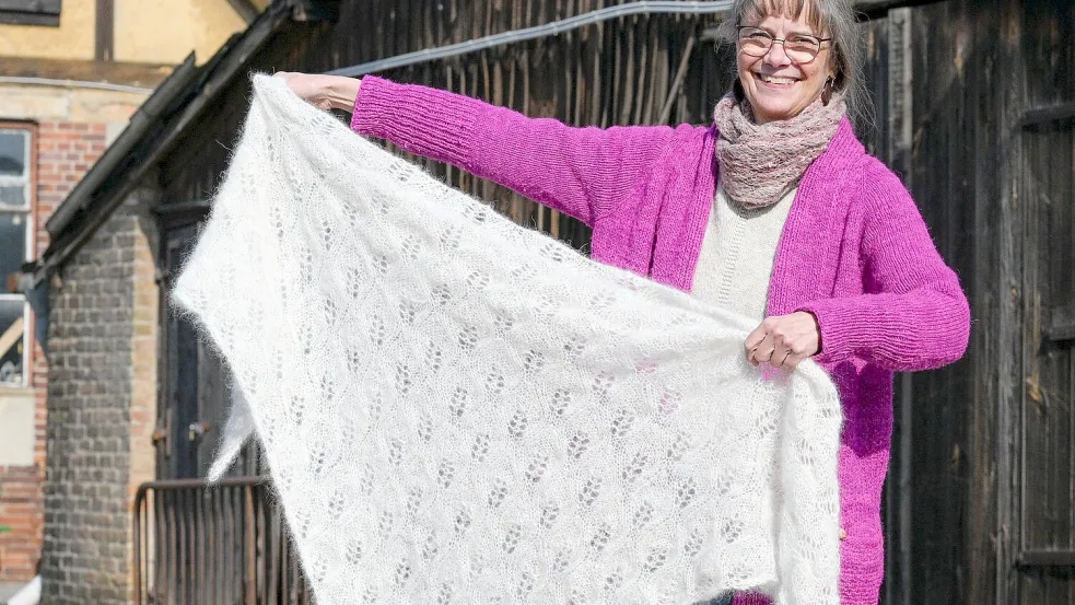 Weberin Svenja Suhr mit ihrem Dreieckstuch aus Hundewolle: Die Wolle fühlt sich so flauschig an wie Angora. Foto: Jens Kalaene/dpa